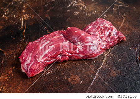 Raw machete skirt beef steak on butcher table. Dark background. Top view Raw machete skirt beef steak on butcher table. Dark background. Top view 83718116