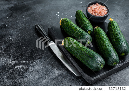 Ripe Green Cucumbers on a marble board. Black background. Top view. Copy space Ripe Green Cucumbers on a marble board. Black background. Top view. Copy space 83718182