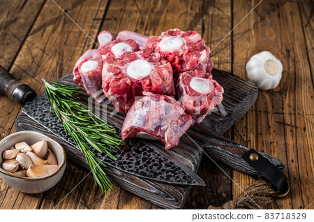 Raw beef Oxtail cut Meat on wooden cutting board with knife. wooden background. Top view 83718329
