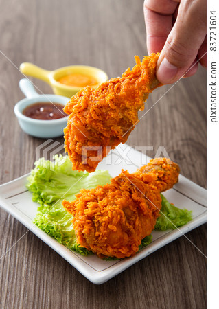 hand holding crispy and golden fried chickens 83721604