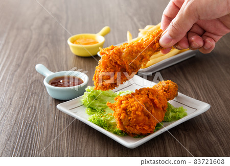 hand holding crispy and golden fried chickens 83721608