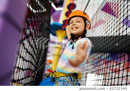 Little girl climbs on the ropes, zip line Little girl climbs on the ropes, zip line 83722149