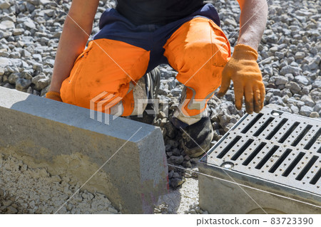 Municipal worker laying water drainage construction on well concrete Municipal worker laying water drainage construction on well concrete 83723390