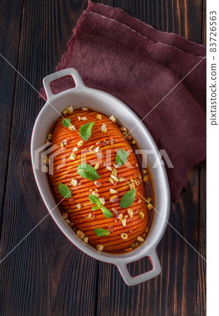 Baked hasselback pumpkin glazed with caramel in baking pan Baked hasselback pumpkin glazed with caramel in baking pan 83726563