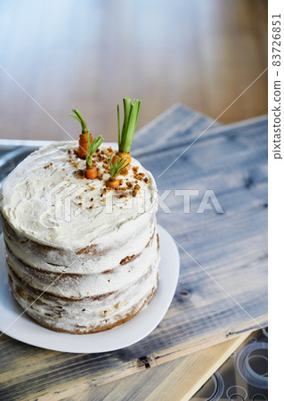 Carrot cake stands on a white plate on the table. View from above Carrot cake stands on a white plate on the table. View from above 83726851