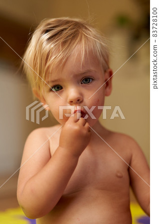 Small child with a dirty face holds his fingers in his mouth Small child with a dirty face holds his fingers in his mouth 83728100