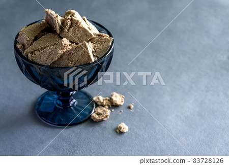 Sunflower halva in a vase on a gray background. Made from sunflower seeds. Sunflower halva in a vase on a gray background. Made from sunflower seeds. 83728126