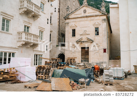 Repair work near the temple. Building materials lie on pallets at a construction site Repair work near the temple. Building materials lie on pallets at a construction site 83728272