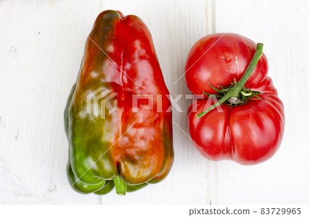 Multicolored sweet peppers and tomatoes on wooden table. Studio Photo. 83729965