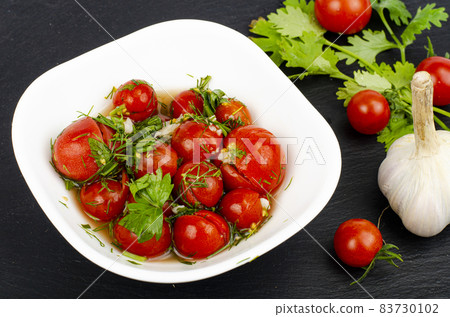 Pickled tomatoes with herbs and garlic. Studio Photo. Pickled tomatoes with herbs and garlic. Studio Photo. 83730102