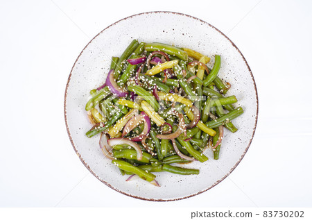 Vegetarian green bean pod dish with red pickled onions and sesame seeds. Studio Photo Vegetarian green bean pod dish with red pickled onions and sesame seeds. Studio Photo 83730202