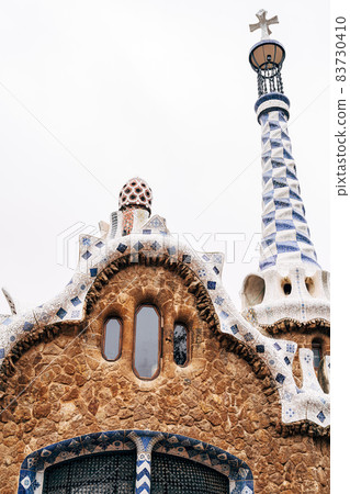 The central entrance to The Park Guell in Barcelona. Gingerbread houses. Right house, close-up of roof and tower. 83730410