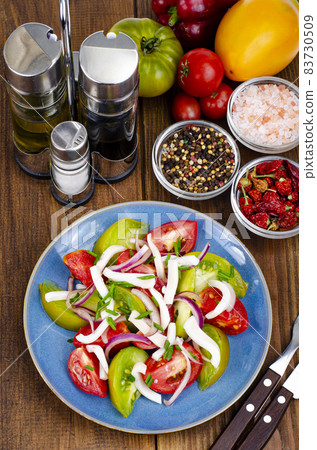 Healthy vegetable salad with tomatoes and squid pieces. Studio Photo. Healthy vegetable salad with tomatoes and squid pieces. Studio Photo. 83730509