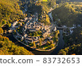 Aerial view of Esch-sur-Sure medieval town in Luxembourg famous for its ancient Castle. Forests of Upper-Sure Nature Park, meander of winding river Sauer, near Upper Sauer Lake. Canton Wiltz. 83732653