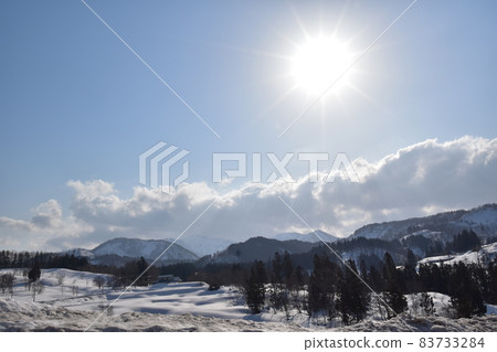太陽的光芒照亮覆蓋著雪的土地的風景 83733284