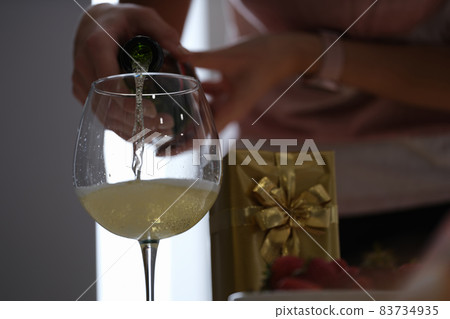 Woman pouring champagne into a glass, celebration Woman pouring champagne into a glass, celebration 83734935