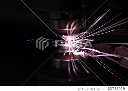 Sparks from metal on a dark background, close-up Sparks from metal on a dark background, close-up 83735019