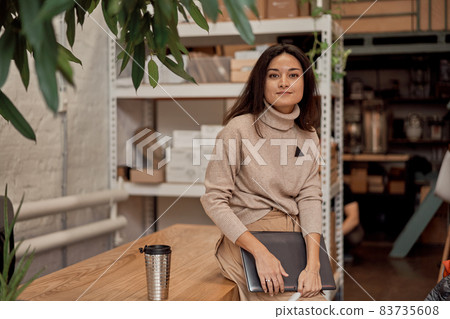 Female freelancer taking break in workspace Female freelancer taking break in workspace 83735608