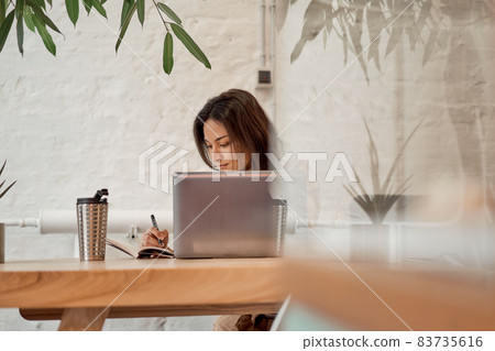 Female freelancer making notes in notebook 83735616