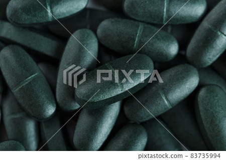 Green tablets of vitamins from spirulina as a textural background in full screen. Green tablets of vitamins from spirulina as a textural background in full screen. 83735994