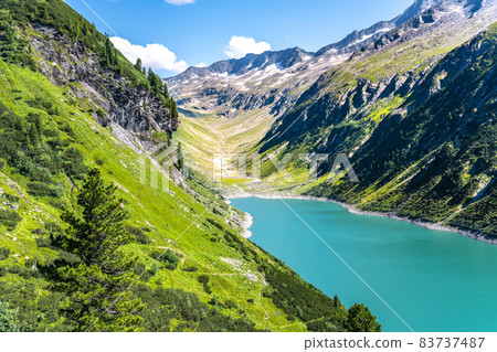 Vivid blue mountain lake in summer Alps Vivid blue mountain lake in summer Alps 83737487