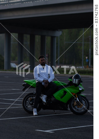 Stylish man on motorbike in evening 83742768