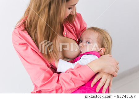 Foto de Breastfeeding baby close up. Pretty mother holding her