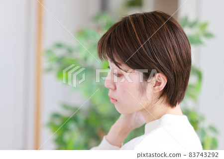 一個女人照鏡子，檢查她的髮型 1 的個人資料 83743292