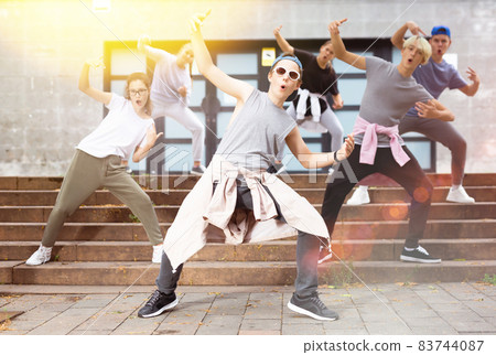 Teen boy dancing modern street dance with teenagers Teen boy dancing modern street dance with teenagers 83744087