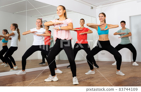 Teenagers exercising with coach in choreography class 83744109