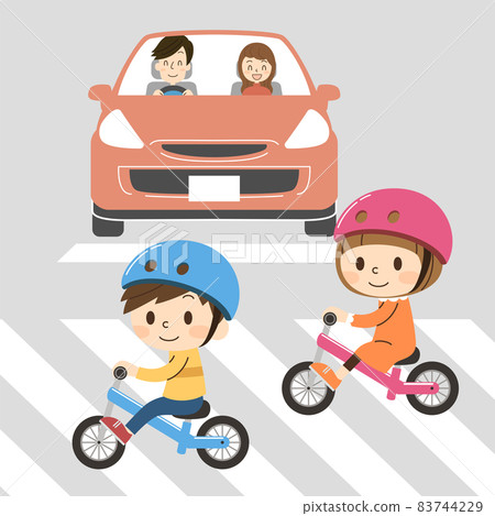 Two children biking across the pedestrian crossing 83744229
