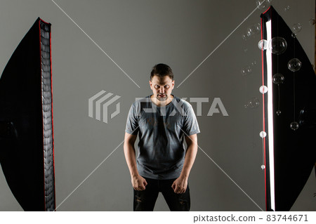 A man model in the studio on a white background. professional shooting and lighting in the studio. angry guy 83744671