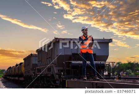 Engineer railway under checking construction process train testing and checking railway work on railroad station with radio communication .Engineer wearing safety uniform and safety helmet in work. Engineer railway under checking construction process train testing and checking railway work on railroad station with radio communication .Engineer wearing safety uniform and safety helmet in work. 83746071