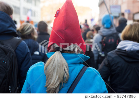 Portrait on back view of woman wearing a french revolutionary hat in the street 83747896
