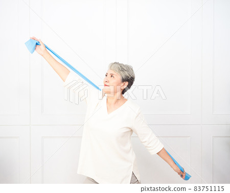 Senior asian woman doing exercises with resistance band at home. Senior asian woman doing exercises with resistance band at home. 83751115