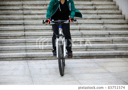 Woman freerider riding down city stairs Woman freerider riding down city stairs 83751574
