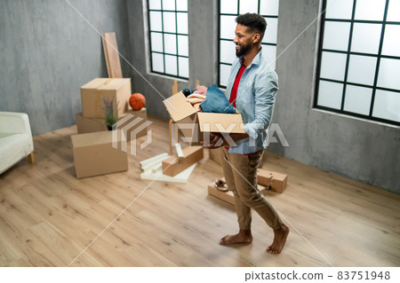 High angle view of happy young man holding packing boxes moving home, new living concept. High angle view of happy young man holding packing boxes moving home, new living concept. 83751948