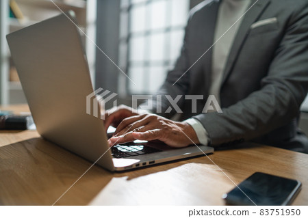 Close up of african american businessman working on a laptop indoors in office 83751950
