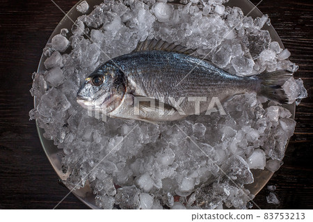 Seafood cooking preparation. Top view of dorado on ice. Seafood cooking preparation. Top view of dorado on ice. 83753213