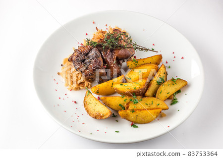 Delicious grilled duck wings with potatoes and stewed cabbage on a white plate Delicious grilled duck wings with potatoes and stewed cabbage on a white plate 83753364
