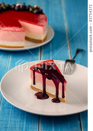Cheesecake with blueberries on a white plate on a blue wooden background 83754372