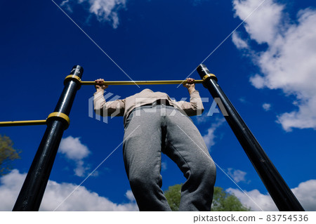Caucasian sportsman on crossbar during street workout. Healthy lifestyle and street sport concept 83754536