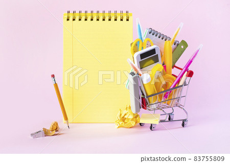 Shopping cart with school supplies on the pink background. 83755809