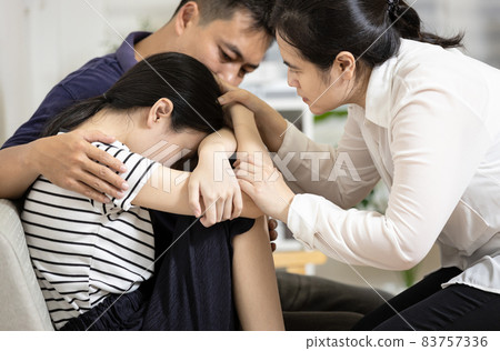 Depressed teenager girl with depressive symptoms,depression disease,feels sad crying,asian mom and dad hugging embracing daughter together,giving love warmth,family care,mental health problems concept Depressed teenager girl with depressive symptoms,depression disease,feels sad crying,asian mom and dad hugging embracing daughter together,giving love warmth,family care,mental health problems concept 83757336