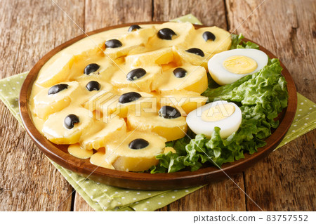 Peruvian cuisine Papa a la Huancaina or potatoes Huancayo style boiled potatoes are topped with a creamy cheese sauce close up in the plate. Horizontal 83757552