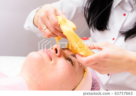 The process of removing the cosmetic golden mass, cosmetic procedures in the salon. The process of removing the cosmetic golden mass, cosmetic procedures in the salon. 83757663