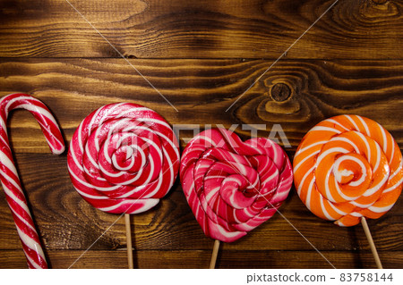 Sweet lollipops on rustic wooden background. Top view Sweet lollipops on rustic wooden background. Top view 83758144
