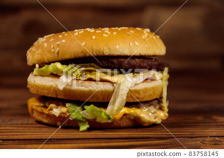 Delicious big hamburger on wooden table Delicious big hamburger on wooden table 83758145