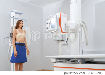 Brunette woman scanning lungs in cabinet of radiology. Brunette woman scanning lungs in cabinet of radiology. 83758203