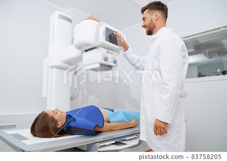 Radiologist wearing uniform using ultra sound tool above woman. Radiologist wearing uniform using ultra sound tool above woman. 83758205